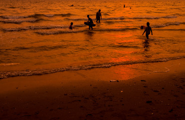 Fototapeta na wymiar People are swimming in the sea, relaxing. At sunset