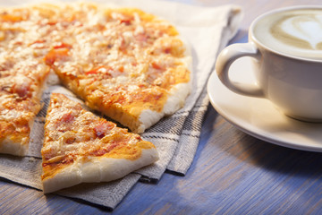Pizza and Coffee on wooden table, cup of cappuccino.