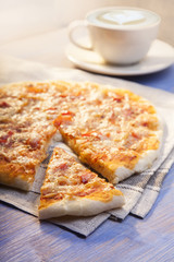 Pizza and Coffee on wooden table, cup of cappuccino.