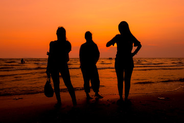 Woman is walking on the beach relaxing at sunset.