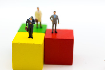 Miniature people : Businessman standing on wooden blocks color. Image use for business concept.