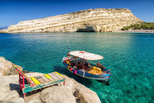 Fototapeta Clear sea and boat at Matala resort. Crete, Greece