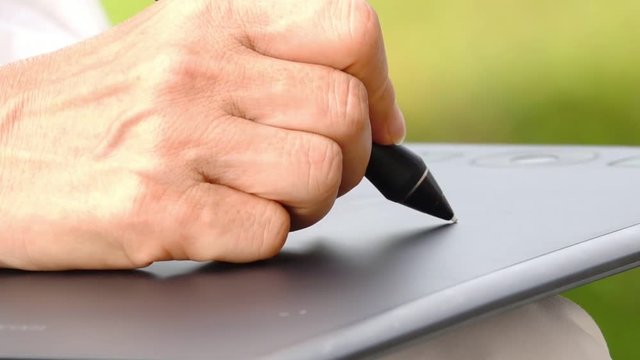 Tablet and pen .
Woman working with tablet and pen in backyard home ,digital life concept.
