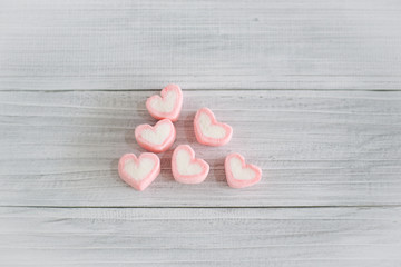 Pink Heart shape marshmallow on white wooden table  background