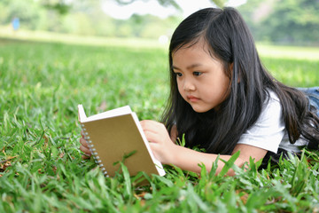 Education Concepts. The girl is reading a book in the garden. Beautiful girl is seriously studying. Beautiful girls are happy learning.