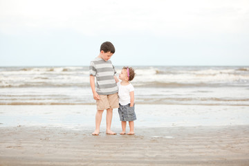 Children standing on beach with waves