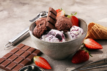 Chocolate coffee ice cream ball in a bowl and strawberry and vanilla