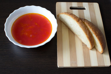 Суп в тарелке и нарезанный хлеб