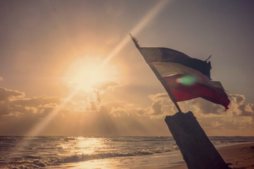 Flag of the Dominican Republic. Sunrise over the sea