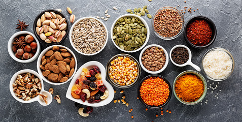 Composition with assortment of superfood products in bowls on gray background, top view