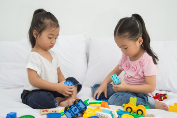 Concepts of learning skills. Little Children are learning skills to play with toys. Little Children are playing in the playroom. Asian Little Children playing with friends in the bedroom