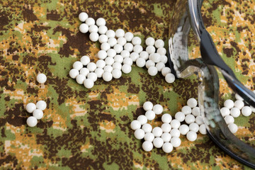 Obraz na płótnie Canvas balls airsoft bbs and protective glasses on a camouflage background
