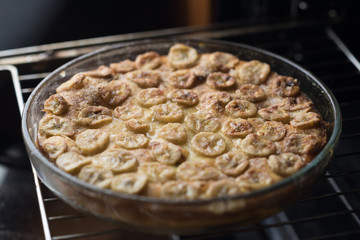 Cake with bananas on a glass plate in the oven