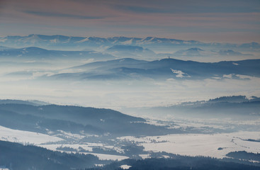 Fototapeta na wymiar Elevated view of sunny winter scenery with blue mountain ridges and valleys filled with fog in Orava and Liptov regions, Oravska Magura Chocske vrchy Nizke Tatry ranges Slovakia Eastern Central Europe