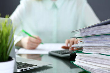 Bookkeeper or financial inspector  making report, calculating or checking balance. Binders with...
