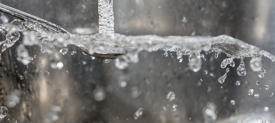 Obraz na płótnie Canvas Spritzendes Wasser vom Löffel beim Abwasch