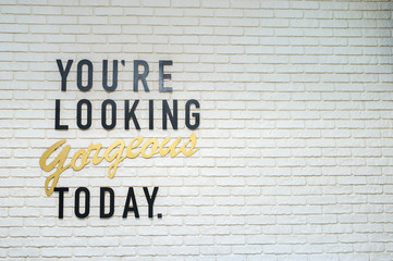 Inscription blank on a white brick wall. You're looking gorgeous today