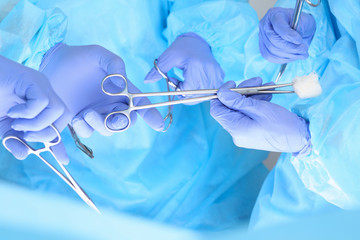 Close-up of unknown surgeons at work while operating at hospital. Health care and veterinary concept