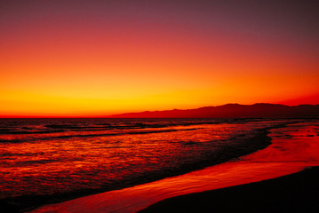 A beautiful Santa Monica beach coastline  at sunset with stunning sky and its relfecting light on the ocean waves below.