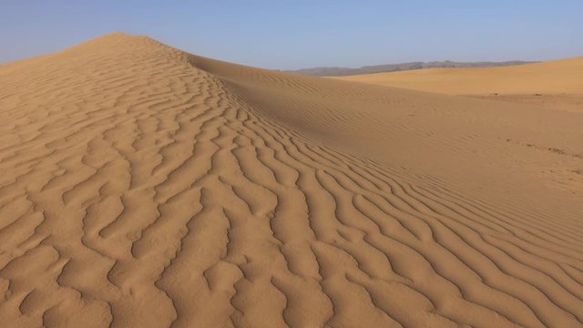 Sand blowing over sand dunes in wind, Sahara desert, 4k
