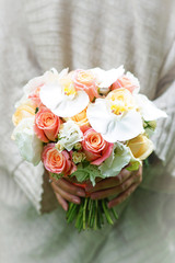 young bride in a beautiful dress holding a bouquet in hands