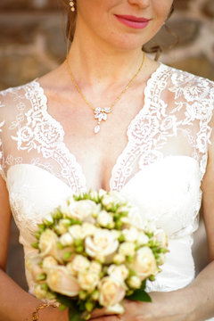 young bride in a beautiful dress holding a bouquet in hands