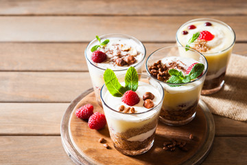Dessert with berries, jelly, cream, nuts and mint leaf on a cutting wooden board 