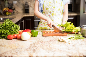 Woman chopping vegetables on kitchen counter