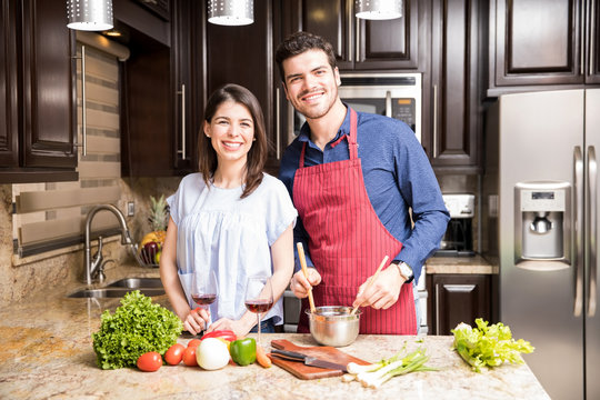 Beautiful latin couple cooking in kitchen