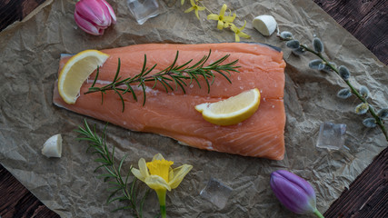 Salmon for the festive Easter table with rosemary and lemon on crumpled paper.