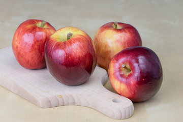 Naklejka na ściany i meble Tasty and ripe apples. Fruit sprinkled with water on a wooden kitchen table.