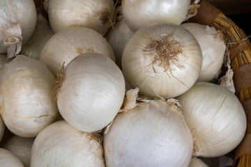 Fresh white onions in a wicker basket