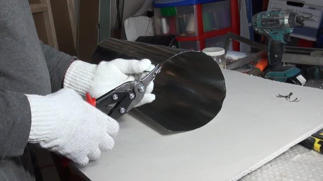 The worker cuts the edge of the pipe to level the edge