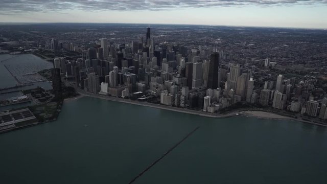 Chicago high altitude wide aerial view flying over Lake Michigan looking towards the downtown core city skyline featuring Jardine Water Purification Plant in the foreground