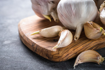 Garlic cloves on a dark stone background. 