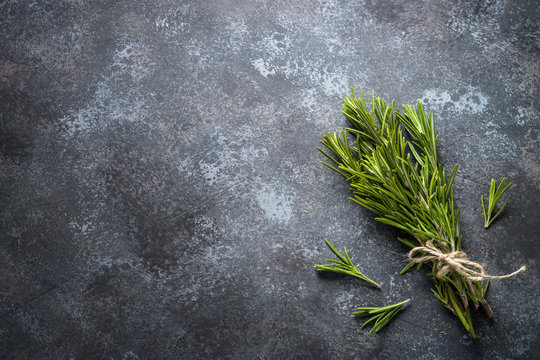 Sprigs of rosemary on black top view.