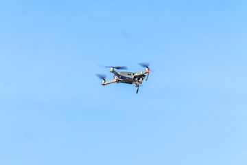 Fototapeta na wymiar drone quad copter with high resolution digital camera flying hovering in the blue sky.