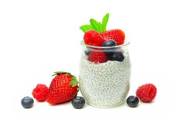 Healthy berry chia pudding in a jar with scattered fruit isolated on a white background