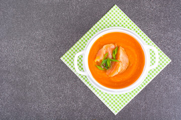 Carrot, pumpkin cream soup with salmon