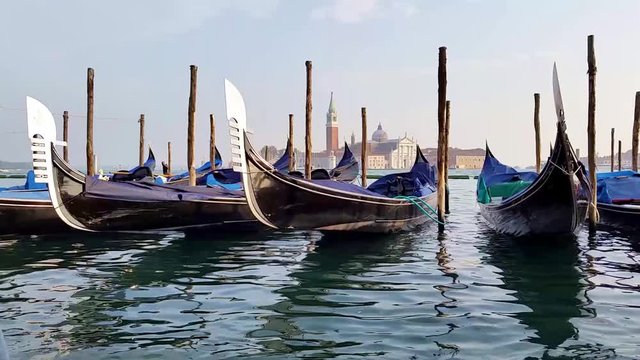 Gondolas of Venice, Italy bobbing in the waters of the lagoon with church view behind