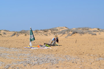 isolated beach umbrella and deck chairs on the beach in summer