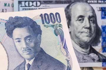 1000 yen with hundred dollar bill on background