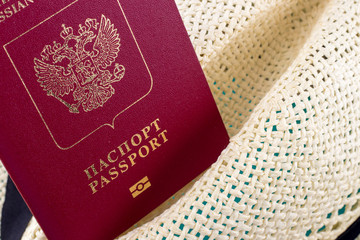 Fototapeta premium Close-up of red russian passport in hat. Concept of traveling