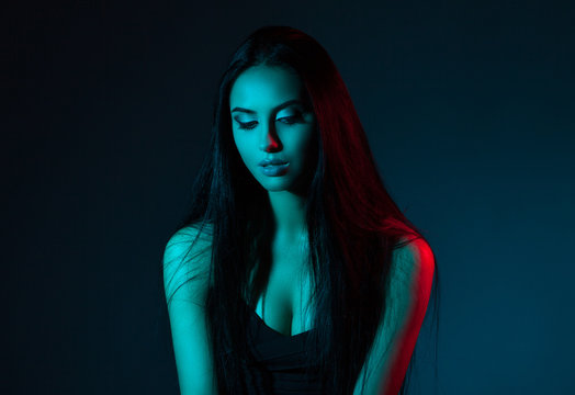Creative Studio portrait of beautiful female model close-up. The blue lights.