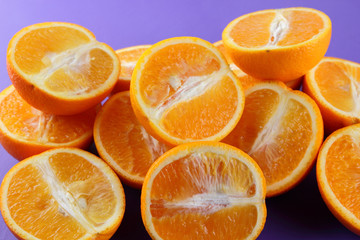 Fruit oranges on a purple background, a lot of orange halves for vegan, sliced citrus fruits for breakfast, fruit pop art pattern, vitamin set designer, juicy orange fruit