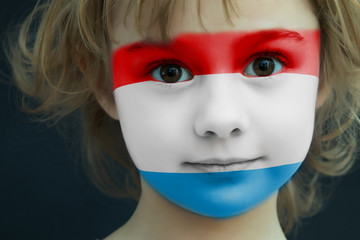 Child with a painted flag of Luxembourg