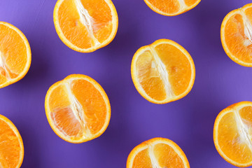 Sliced fruit oranges in checkered pattern on a purple background, symmetrically laid out citrus in pop art style, fruit pattern of halves of oranges, ultraviolet, minimalism, art