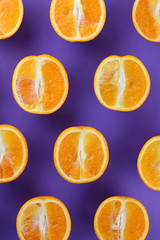 Sliced fruit oranges in checkered pattern on a purple background, symmetrically laid out citrus in pop art style, fruit pattern of halves of oranges, ultraviolet, minimalism, art