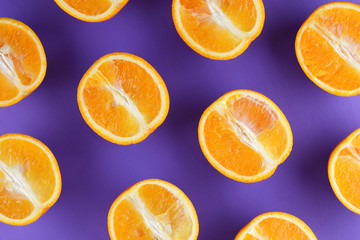 Sliced fruit oranges in checkered pattern on a purple background, symmetrically laid out citrus in pop art style, fruit pattern of halves of oranges, ultraviolet, minimalism, art