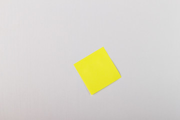 yellow sticky note on a white wooden wall